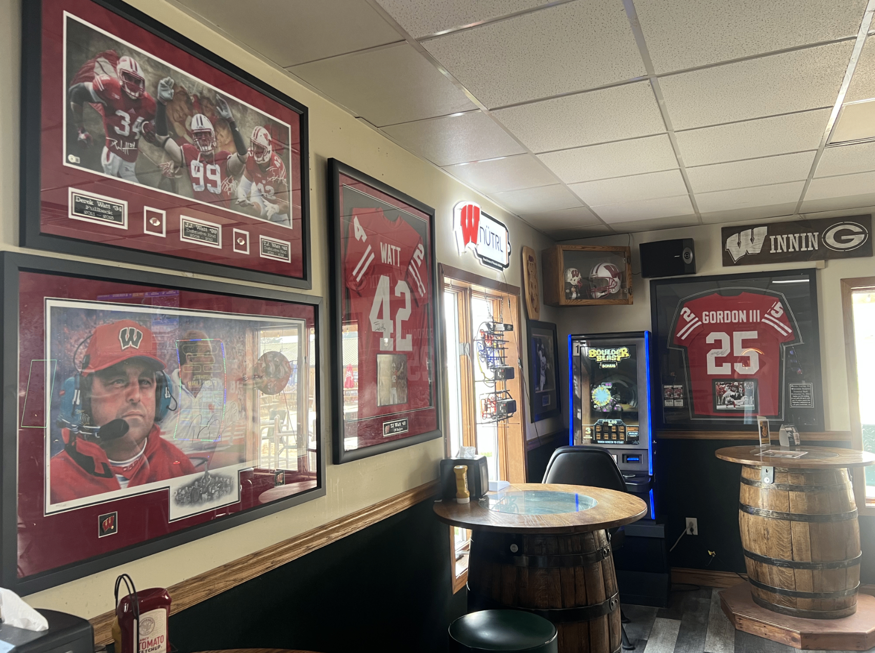 Wall of framed Badger and Packer jerseys and photos at The Zone